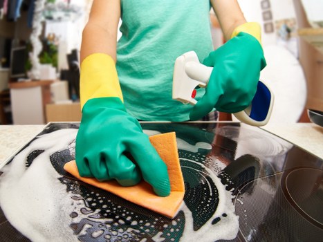 Technician cleaning a built-in oven in a Shoreditch flat kitchen